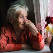 Einsame Frau schaut aus dem Fenster