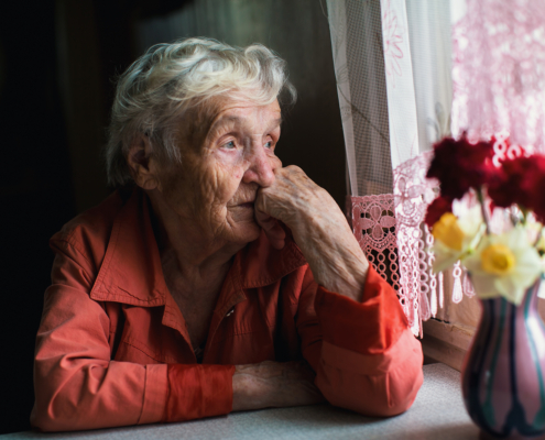 Einsame Frau schaut aus dem Fenster