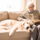 Frau mit Hund und Buch auf dem Sofa