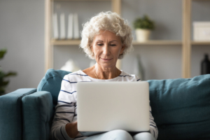 Seniorin sitzt am PC und nutzt FonPartner